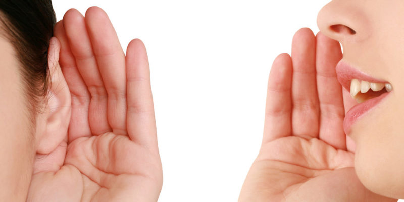 dos personas representan el acto de escuchar y de hablar, usan sus manos para dar apoyo a la oreja y a la boca.